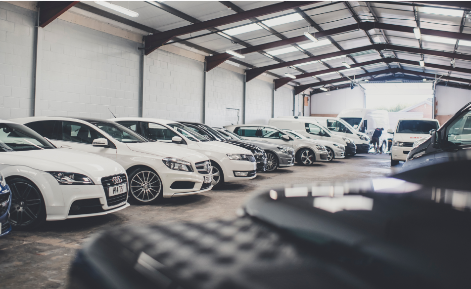 A vehicle showroom with cars and vans lined up