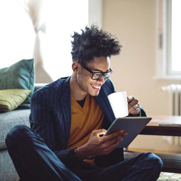 A consumer drinking a hot drink whilst browsing Autotrader via a digital device